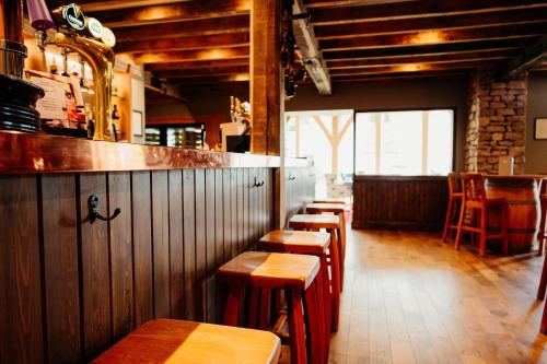 a row of wooden tables and chairs in a restaurant at The Fleece at Ruleholme in Carlisle
