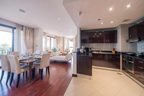 a kitchen and dining room with a table and chairs at Luxe Getaways Royal Amwaj Palm Jumeirah Resort Apartment Holiday Home in Dubai
