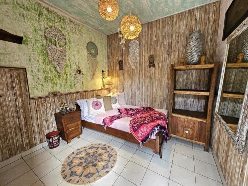 a bedroom with a bed in a room with wooden walls at Lovina Loca in Lovina