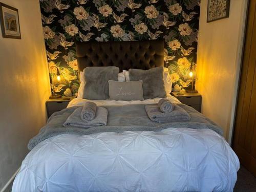 a bedroom with a large bed with towels on it at Secret Gem 1 Bed Garden Flat Private Luxury Hot Tub in Bournemouth