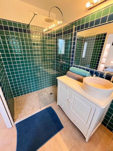 une salle de bain carrelée verte avec un lavabo et un miroir dans l'établissement Un endroit où l'on se sent bien, à Roquebrune-sur Argens