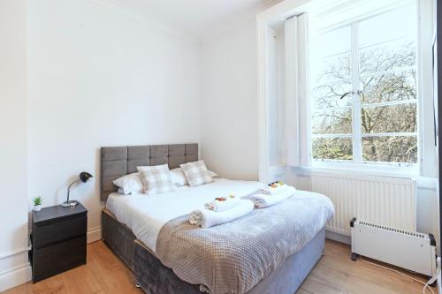 a bedroom with a bed with two towels on it at Luxury 2 Bedroom Flat In Royal Crescent in London