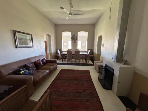 a living room with a couch and a dining room at Ghanzi Farmhouse in Ghanzi