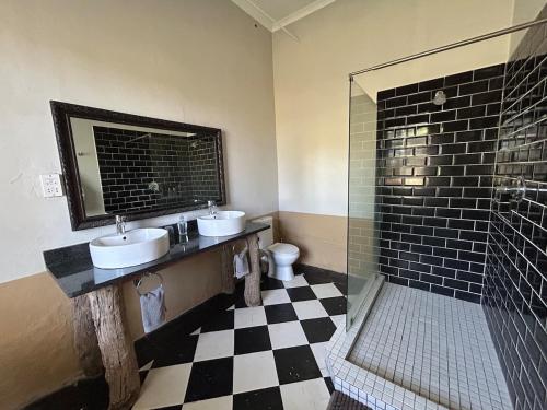 a bathroom with two sinks and a shower at Ghanzi Farmhouse in Ghanzi