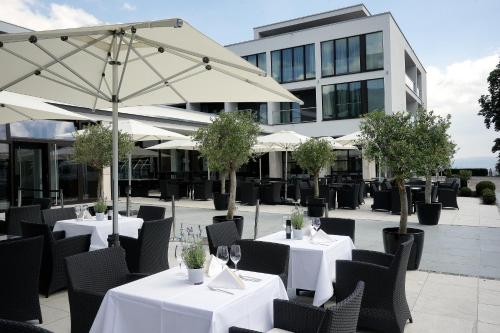 a restaurant with white tables and chairs and an umbrella at Schlosshotel Kassel in Kassel
