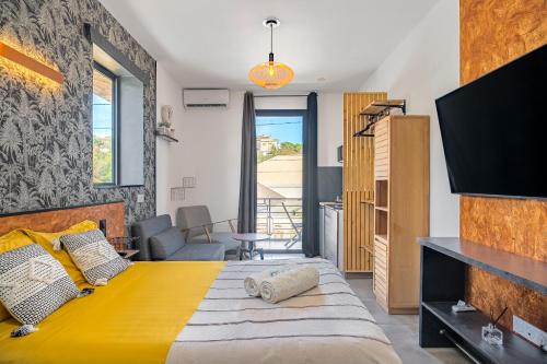a bedroom with a yellow bed and a tv at Au temps des pêcheurs - Terre Sainte - Piscine chauffée in Saint-Pierre