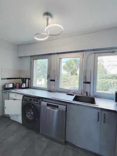 une cuisine avec un évier et une machine à laver dans l'établissement Chez Line, à Bandol