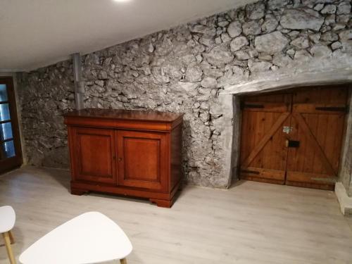 Cette chambre est dotée d'un mur en pierre et d'une porte en bois. dans l'établissement Les glycines, au Cannet-des-Maures
