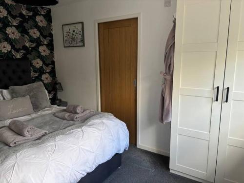 a bedroom with a bed with towels on it at Secret Gem 1 Bed Garden Flat Private Luxury Hot Tub in Bournemouth