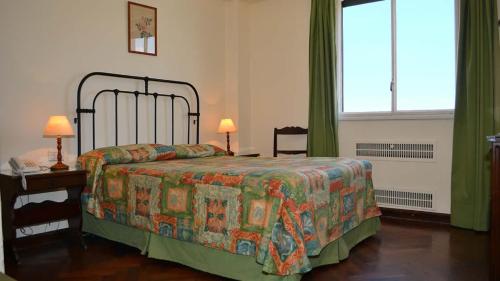 a bedroom with a bed and a table and a window at Hotel Salta in Salta