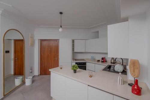 a kitchen with white counters and a brown door at TCE Bel Azur Residency - Ocean & Hassan II View in Casablanca-Port