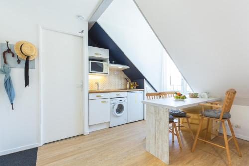 une cuisine avec une table et une cuisinière four supérieur dans l'établissement Le Perchoir, avec parking, face aux Thermes, à Luchon