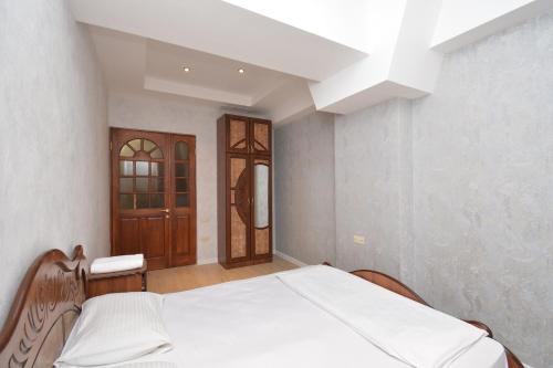 a bedroom with a bed and a wooden door at Apartment in Abovyan Street, Yerevan in Yerevan