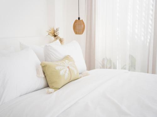 a white bed with a pillow on top of it at Casa Yemi in Munggu