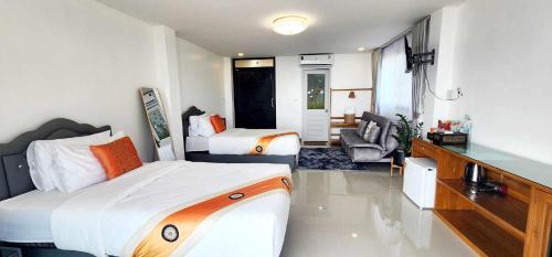 a bedroom with two beds and a living room at Oasis Phamee in Ban Pha Mi