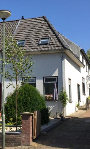 a white house with an umbrella in a window at Greenwoods cottage in Valkenburg