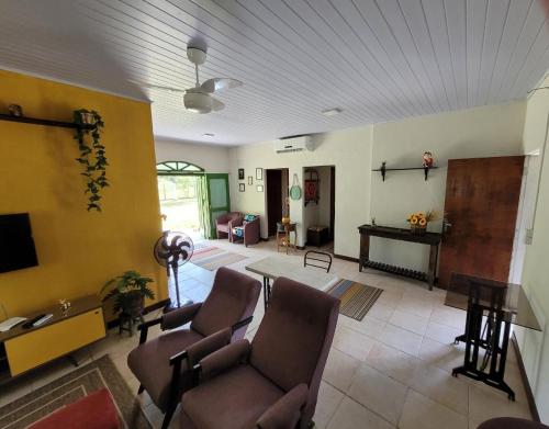 a living room with a couch and chairs and a table at Rancho Bertotti in Guaratuba
