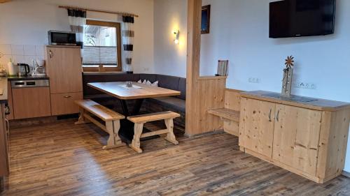 a kitchen with a wooden table and a table and benches at Haus Angelika im Zillertal in Hippach