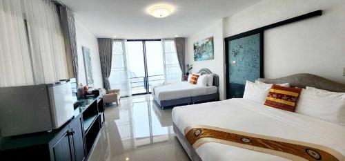 a hotel room with a bed and a television at Oasis Phamee in Ban Pha Mi