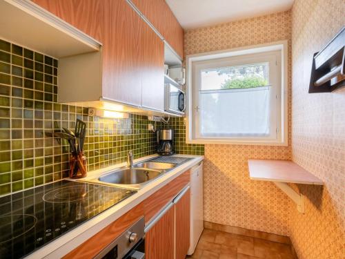 une petite cuisine avec un évier et une fenêtre dans l'établissement Appartement cosy 2 pièces, 5 pers, à 250m plage, terrasse et jardin, garage inclus, Carnac - FR-1-477-94, à Carnac