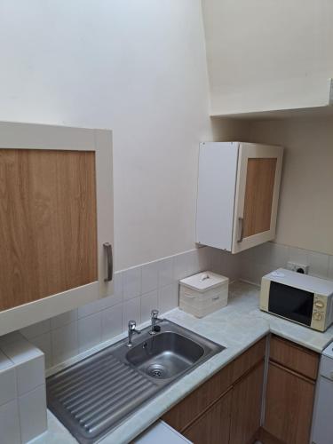 a small kitchen with a sink and a microwave at Bank Top Farm Cottages in Stoke on Trent