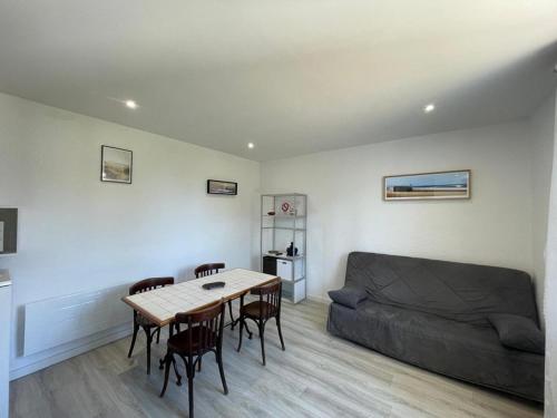 un salon avec une table et un canapé dans l'établissement Appartement cosy avec terrasse, jardin et parking à 200m de la plage - FR-1-413-111, à Capbreton