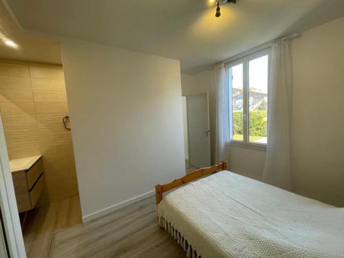 une chambre blanche avec un lit et une fenêtre dans l'établissement Appartement cosy avec terrasse, jardin et parking à 200m de la plage - FR-1-413-111, à Capbreton