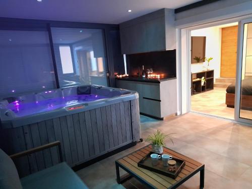 a large tub in a room with a living room at Suite de luxe avec Spa in Saint-Médard-en-Jalles