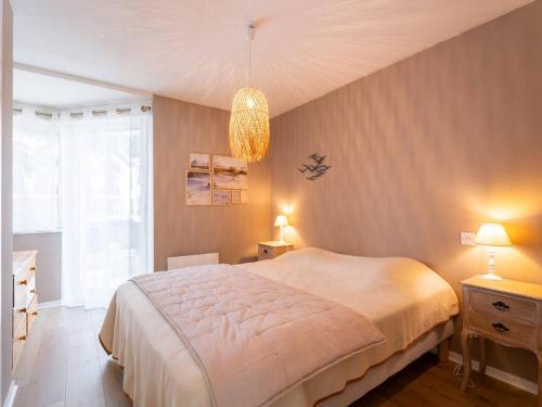 une chambre avec un grand lit et un lustre dans l'établissement Bel appart 3 pièces à 150m de la plage, balcon sud, garage, pour 6 pers. - FR-1-477-206, à Carnac