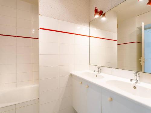 une salle de bain blanche avec un lavabo et un miroir dans l'établissement Bel appart 3 pièces à 150m de la plage, balcon sud, garage, pour 6 pers. - FR-1-477-206, à Carnac