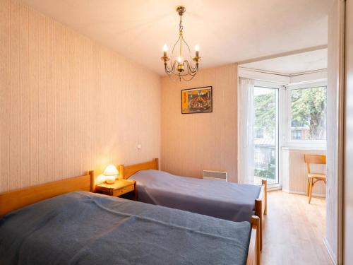 une chambre avec deux lits et un lustre dans l'établissement Carnac Plage: Grand T3 58m² avec Wifi et Parking - FR-1-477-133, à Carnac
