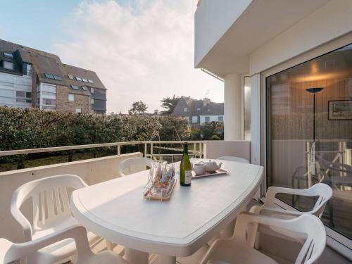 d'une table et de chaises blanches sur un balcon. dans l'établissement Carnac Plage: Grand T3 58m² avec Wifi et Parking - FR-1-477-133, à Carnac