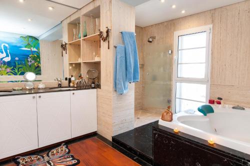 a bathroom with a large tub and a sink at Sonnenland House for 12 by VillaGranCanaria in Maspalomas