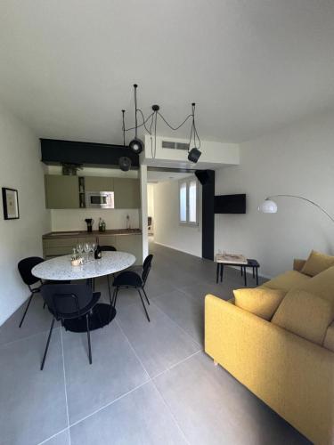 a living room with a yellow couch and a table at Il Giardino Segreto in Faggeto Lario 