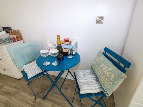 a blue table with wine glasses and a chair at The Hollybush in Kilgetty