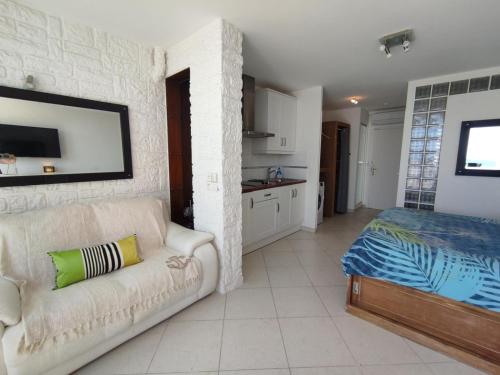 un salon avec un canapé et un lit dans l'établissement Studio C28, Héliopolis C au village naturiste, au Cap d'Agde