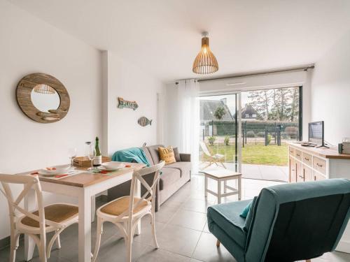 une cuisine et un salon avec une table et des chaises dans l'établissement Carnac - Appartement Moderne 2 Pièces avec Jardin et WIFI - FR-1-477-254, à Carnac
