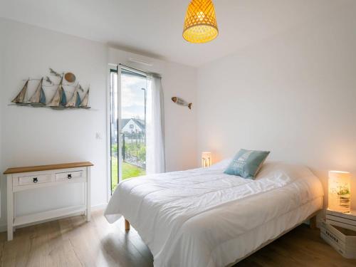 une chambre blanche avec un lit et une fenêtre dans l'établissement Carnac - Appartement Moderne 2 Pièces avec Jardin et WIFI - FR-1-477-254, à Carnac