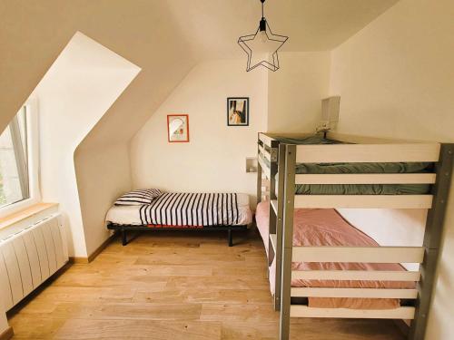 a attic room with a bunk bed and a ladder at Maison lumineuse avec jardin entre plages de Cap-Coz et Beg-Meil, proche activités nautiques - FR-1-481-173 in Fouesnant