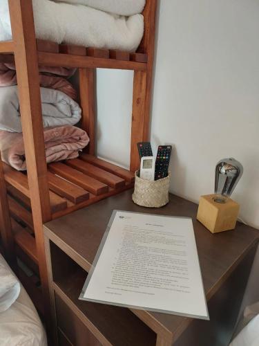 a desk with a book on it next to a bunk bed at Pousada Athena in Palmeiras