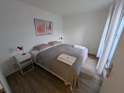 a bedroom with a large bed with a wooden floor at UP&GREAT Apartments - Chic Urban Homes in Zürich