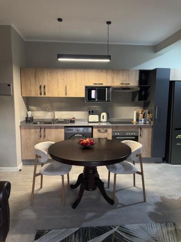 Una cocina con una mesa y sillas en una habitación. en Motswedi Place in Kgale View! Unit L5 1st Floor, en Gaborone