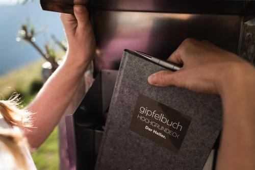 a person is holding a book with a cell phone at Ferienwohnungen Monika Winter in Kleinarl