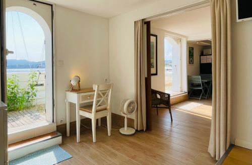 Cette chambre dispose d'une table et d'un bureau avec une fenêtre. dans l'établissement Beach Villa Des Sablettes, à La Seyne-sur-Mer