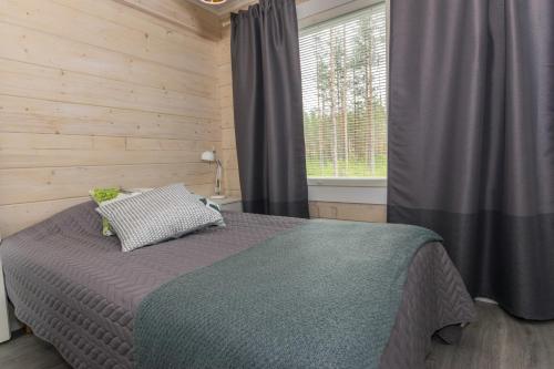 a bedroom with a bed and a window at Villa Hiili in Sonkajärvi