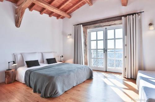 a bedroom with a large bed and a large window at Ferienhaus La Serre in Lentillères