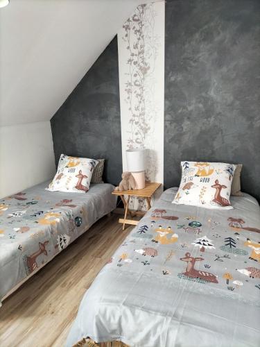 - une chambre avec 2 lits et une table dans l'établissement Joli Cocon,5 min du zoo,au calme,jeux pour enfants, à Châteauvieux