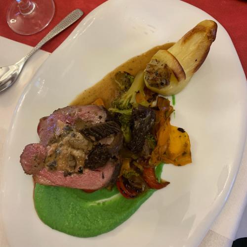 a white plate of food with meat and vegetables at Château de Roques in Teilhet