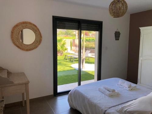 une chambre avec un lit et une porte coulissante en verre dans l'établissement La villa Diya, au Plan-de-la-Tour