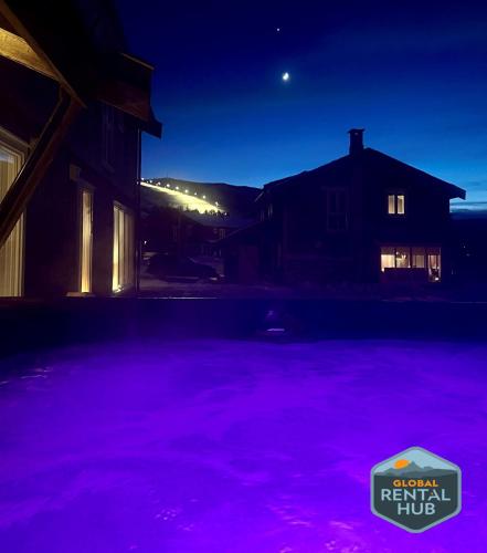a pool filled with purple water at night at Harmony in Geilo, modern and cozy cabin with jacuzzi in Geilo